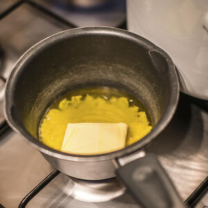 Сливочное масло растопите на минимальном огне на плите, перемешивая, и дайте остыть до комнатной температуры