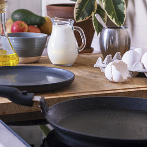 На среднем огне нагрейте сковороду, смажьте кисточкой растительным малом 