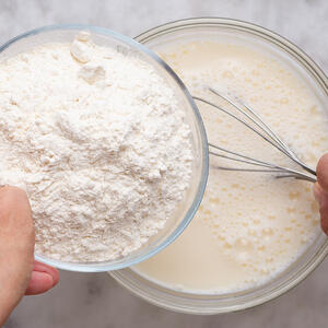 Добавляйте муку частями, перемешивая тесто лопаткой или венчиком.