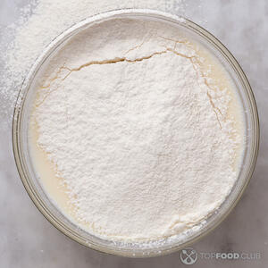 По частям добавляйте просеянную муку, продолжая размешивать тесто венчиком. 