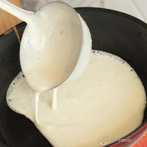 Половником вылейте порцию теста. Поворачивая сковороду, распределите тесто тонким слоем и обжаривайте 1 минуту первую сторону блинчика, пока края не станут золотистыми.