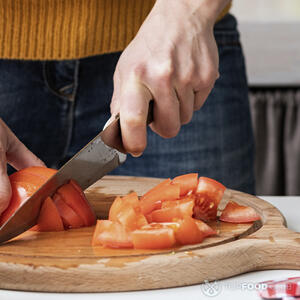 нарезает помидоры