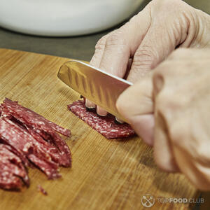 нарезает колбасу