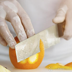 чистит апельсин ножом