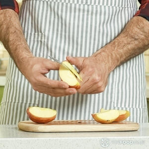 чистит яблоко