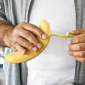 чистит бананы