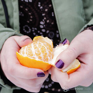 чистит мандарин