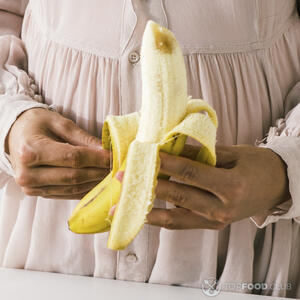 чистит банан