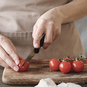 нарезает помидоры