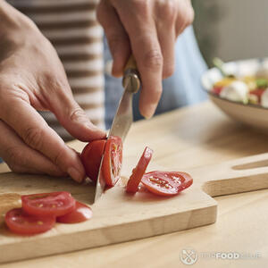 нарезает помидоры