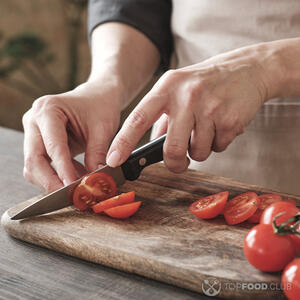 нарезает помидоры