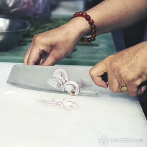 нарезает красный лук