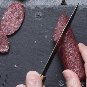 нарезает колбасу