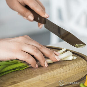 нарезает зеленый лук
