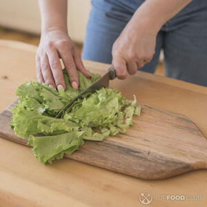 нарезает листья салата