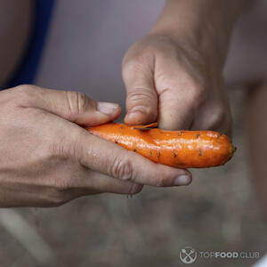 чистит морковь