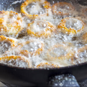 опускайте кольца лука в горячее масло.