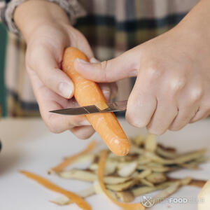 чистит морковь