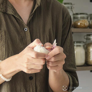 чистит чеснок