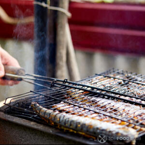 Готовит рыбу