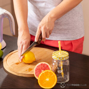 Разрезает лимон на две части