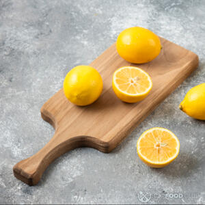 Режет лимон на половину