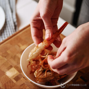 Чистит креветки