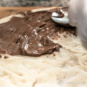 Горячий корж смажьте толстым слоем шоколадной пасты Нутелла