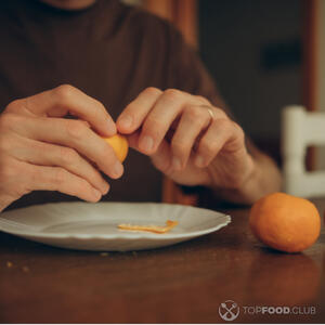 чистит мандарин