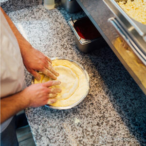 Предварительно смазав форму сливочным маслом выложите тесто на дно формы и посыпьте манной крупой