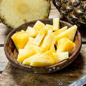 Мякоть ананаса нарежьте небольшими плоскими ломтиками