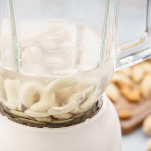 В чашу блендера положите размоченные орехи кешью