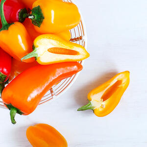 Разрежьте перцы пополам по длине стручка, удалите семена и белые перегородки. 