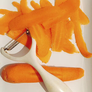 Чистит морковь