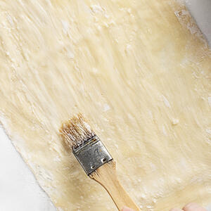 смажьте кисточкой взбитым яйцом и посыпьте кунжутом.