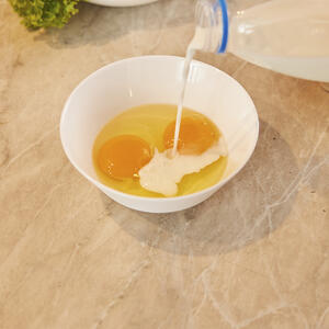 В широкой и неглубокой чашке, вилкой или венчиком, взбейте вместе молоко, яйца и соль.