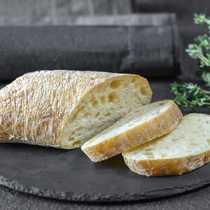 Чтобы приготовить вкусные брускетты, нарежьте чиабатту на ломтики в 1,5 см толщиной