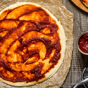 На корж выложите протертые помидоры 