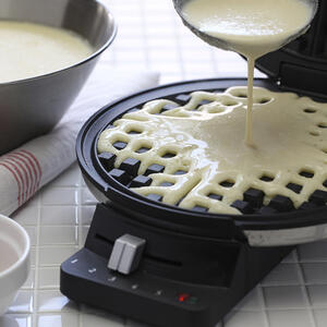 Половником вылейте тесто на нижнюю панель вафельницы