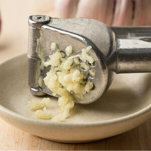 Crush garlic in a press. Season with salt and mix.