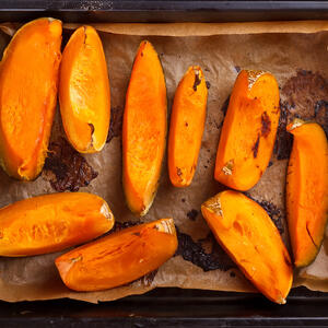 Rinse the pumpkin, peel and remove the seeds. Then cut into stripes and transfer to the baking sheet lined with parchment. 