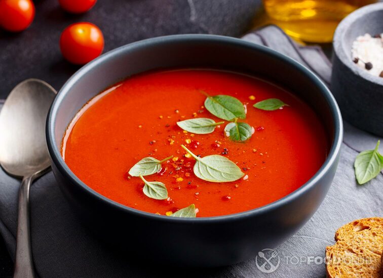 2021-10-06-x7fc1n-tomato-soup-with-basil-in-a-bowl-dark-grey-backgro-xbtuwc4