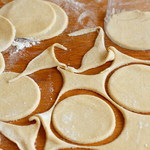 Divide the dough into small parts, make the balls. Sprinkle the table (any flat surface) and roll the balls into 3 in. circles. Place 1 tbsp. of the filling to each circle, make a moon shape and pinch the edges of dumpling