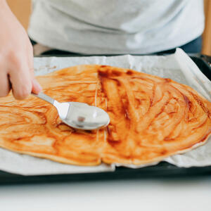 Spoon pizza sauce.