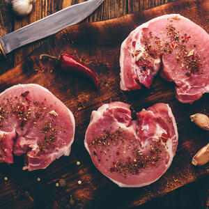 Season the slices of pork tenderloin.
