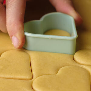 Now when the dough is all rolled out , we need to line the baking tray with some baking paper and cut our cookis into the heart shapes