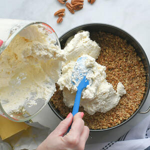 Pouring cheesecake filling over crust