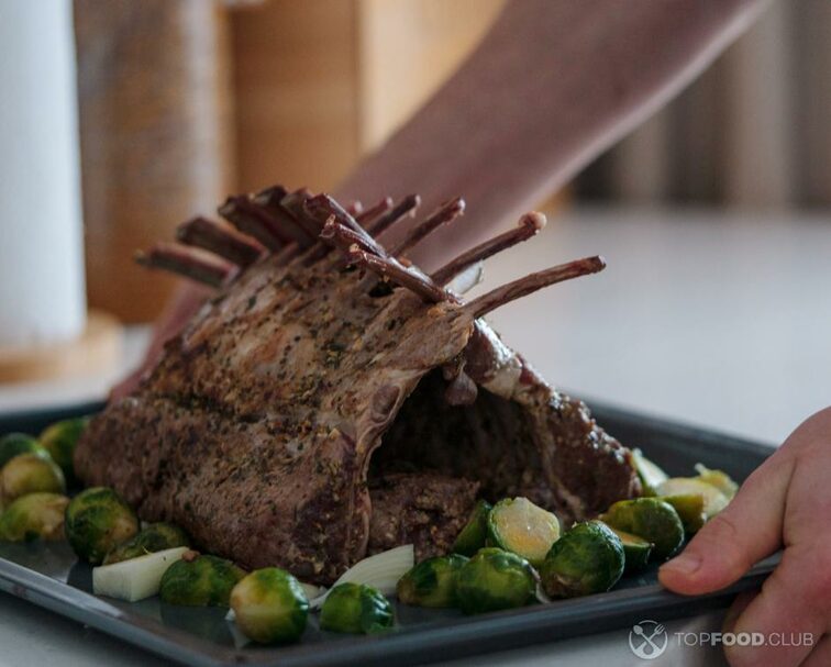 2022-11-21-172ylt-roasted-rack-of-lamb-on-a-tray-in-the-hands-of-the-2022-11-16-23-04-20-utc-1-1