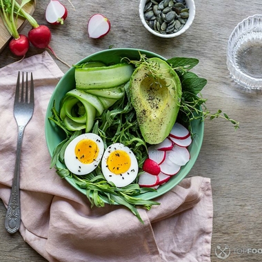 Salad bowl with eggs, arugula, avocado and radishes